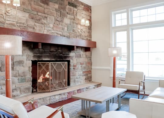 a living room with a fireplace and a table and chairs at Broadlands Apartments, VA 20148